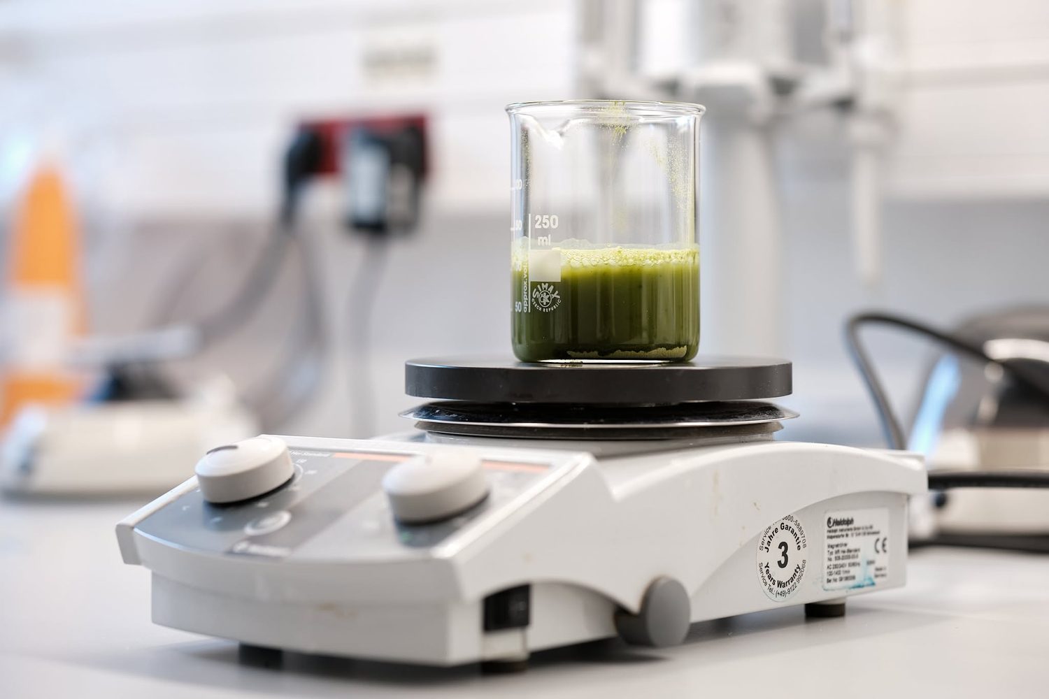 Zielony roztwór kolagenu z matchą w zlewce laboratoryjnej na mieszadle magnetycznym